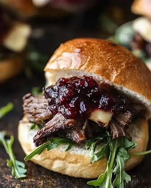 Balsamic Short Rib Sliders with Cranberry Brie & Arugula 1 Balsamic short rib sliders with cranberry brie and arugula on a platter