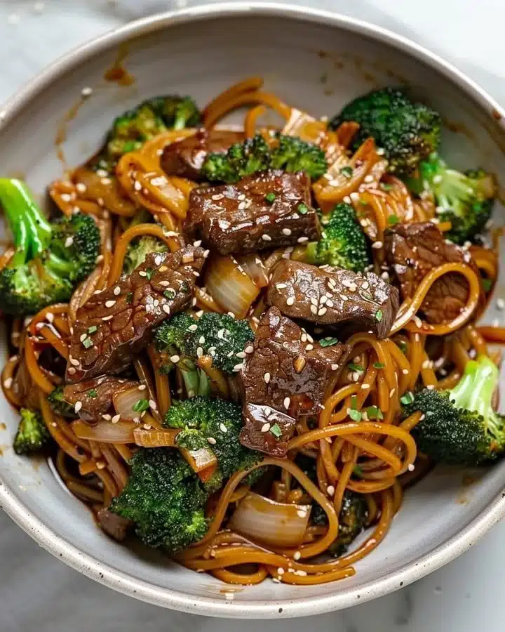 Exotic Ginger Beef and Broccoli Noodle Stir-Fry 1 Exotic ginger beef and broccoli noodle stir-fry dish served with colorful vegetables