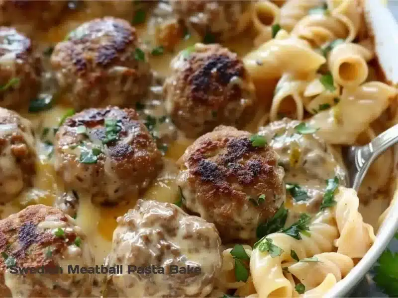 Baked Swedish meatball pasta dish topped with cheese and herbs