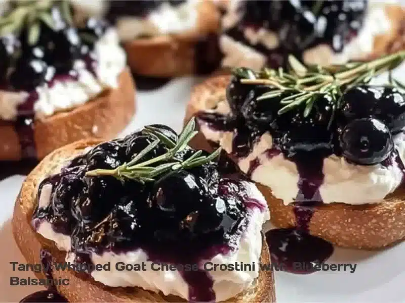 Tangy whipped goat cheese crostini topped with blueberry balsamic drizzle