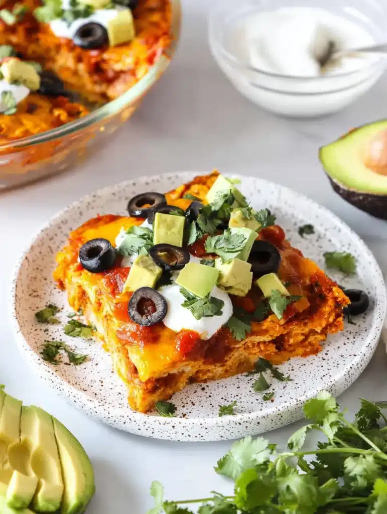 Delicious crustless taco pie topped with cheese, tomatoes, and avocado.