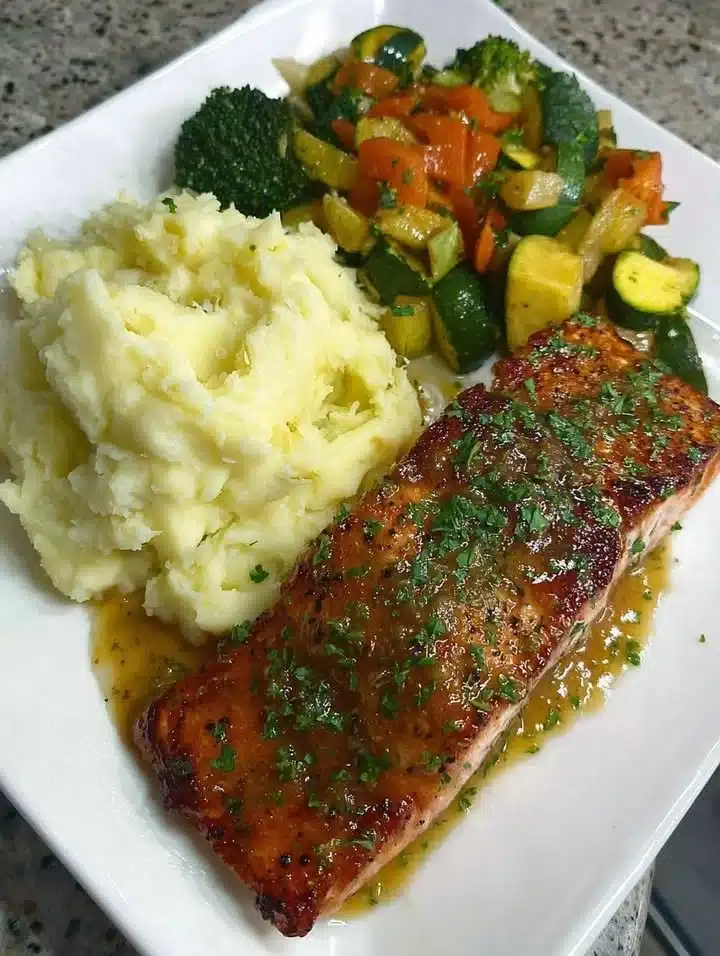 Honey glazed salmon served with mashed potatoes and sautéed vegetables