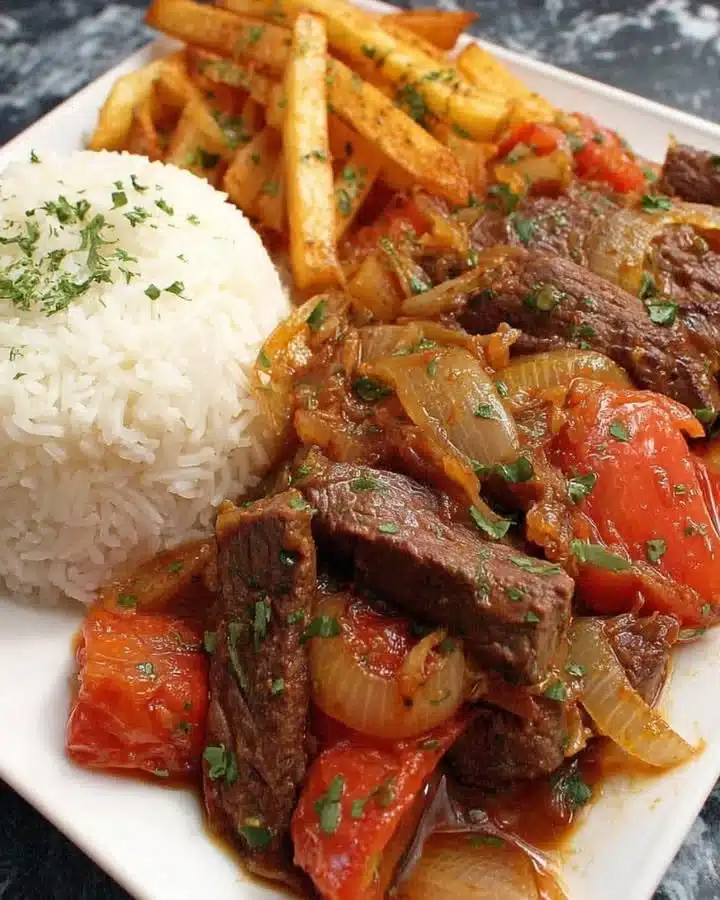 Delicious Peruvian steak stir-fry served with crispy fries on a plate.