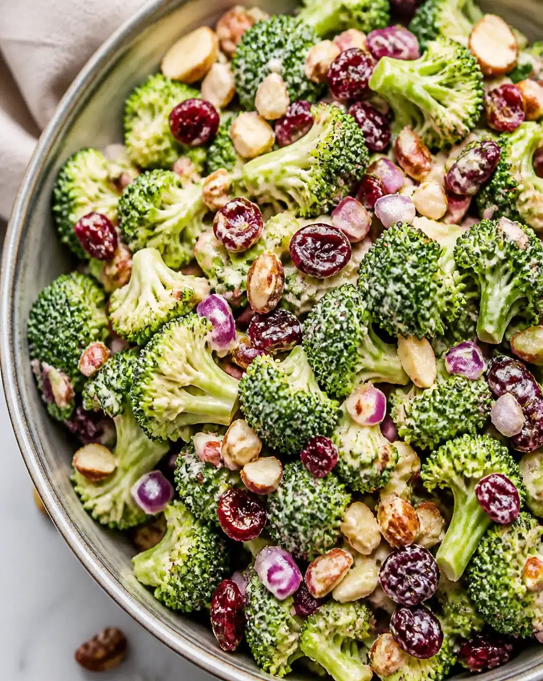 Fresh broccoli salad with nuts and dressing on a wooden table