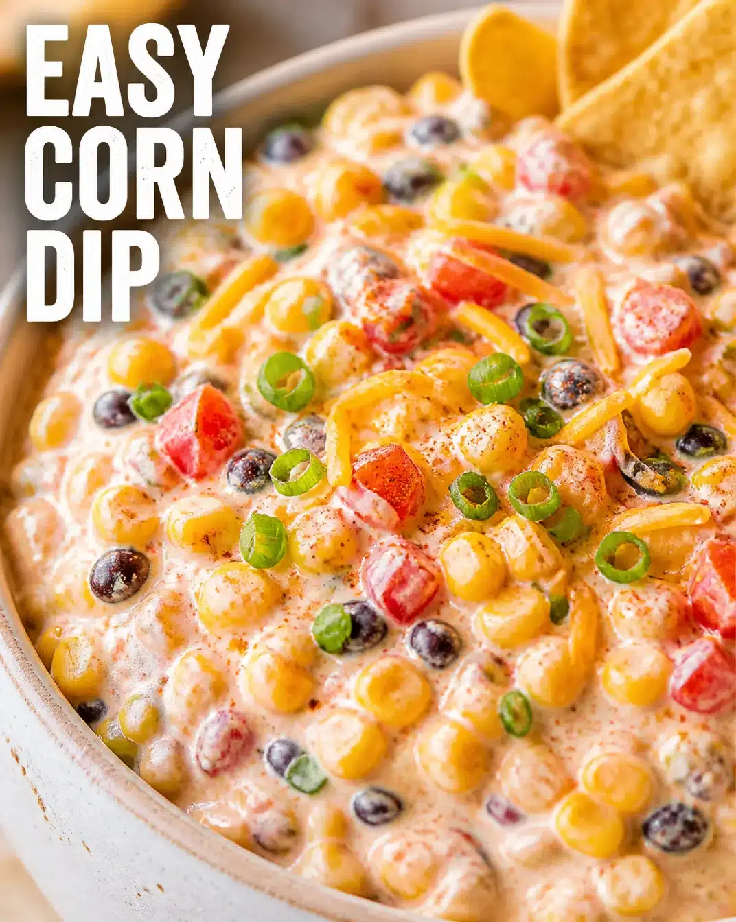 Delicious homemade corn dip served in a bowl with tortilla chips on the side.