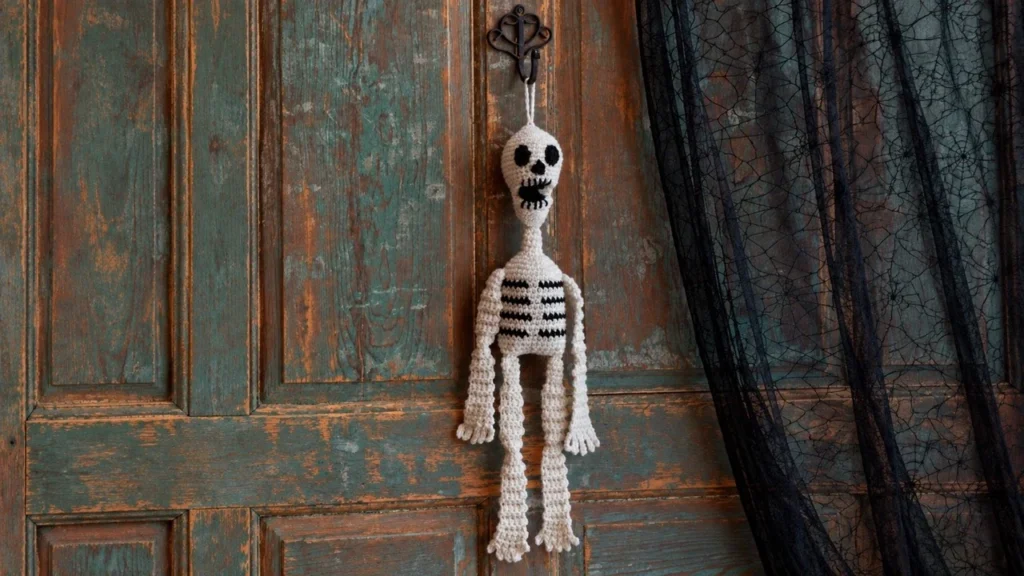 Crochet hanging skeleton pattern on a rustic front door